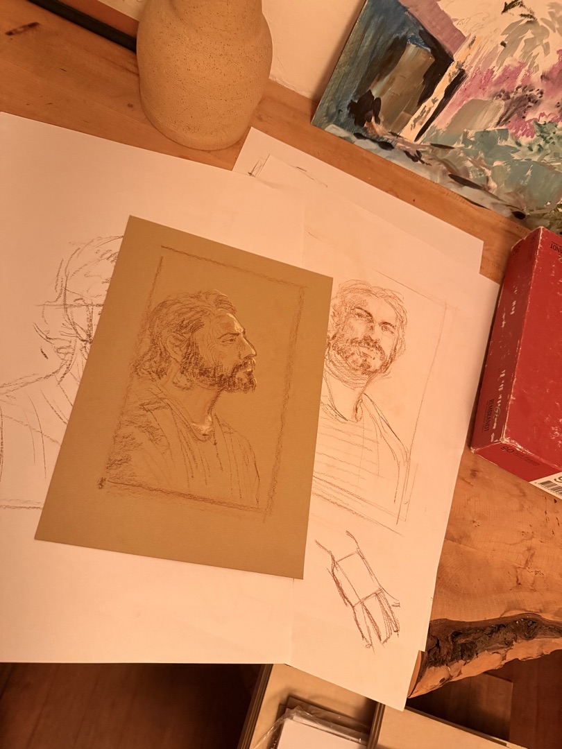 Graphite portrait studies of a bearded man in profile, drawn on toned and white paper